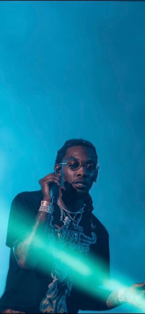 Offset Rapper in Blue Lighting with Stylish Jewelry and Glasses Wallpaper