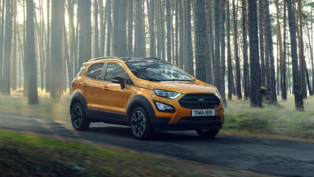 Orange Ford EcoSport Driving Through Forest Road Wallpaper