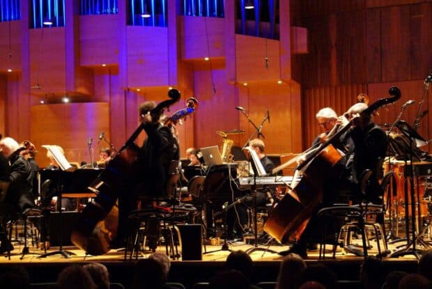 An orchestra performs live on stage playing classical instruments during a concert, HD Desktop Wallpaper
