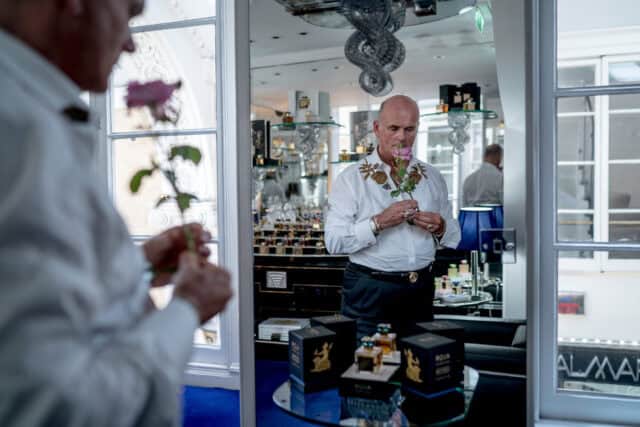 Perfume Enthusiast Enjoys Scented Rose In Luxury Fragrance Store