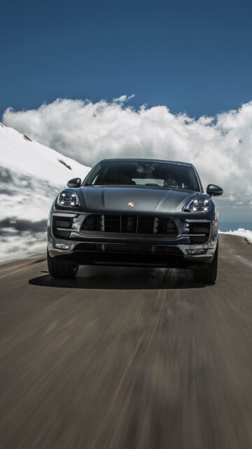 Porsche Macan Driving on Mountain Road with Snow and Blue Sky Background Wallpaper