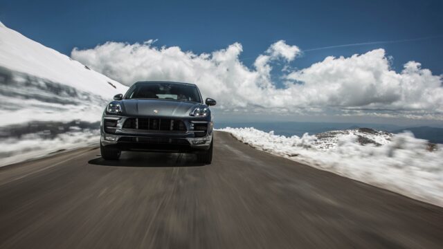 Porsche Macan driving on mountain road with snow and blue sky background Wallpapers