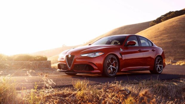 A red Alfa Romeo car is parked on a rural road with hills in the background, HD Desktop Wallpaper