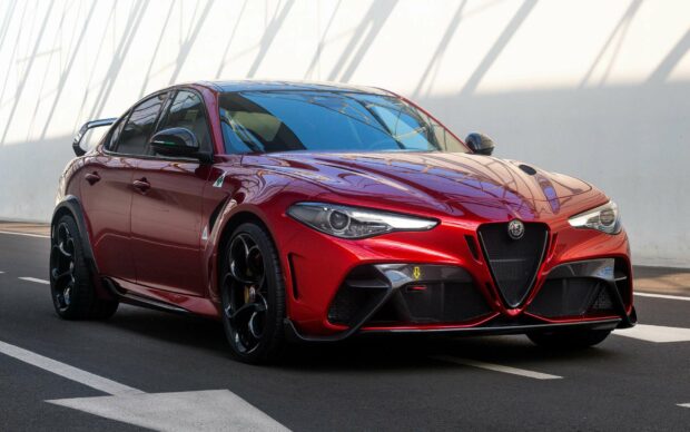 A red Alfa Romeo is parked on an asphalt road with shadows cast on the white wall behind, HD Desktop Wallpaper
