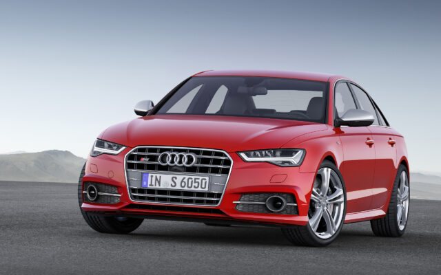 Red Audi S6 Sport Sedan Front View On Open Road Background Wallpaper