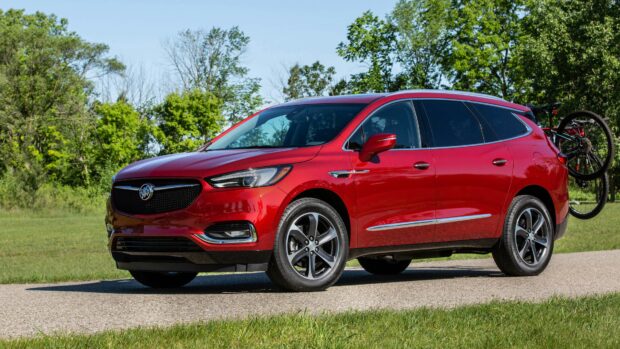 A bright red Buick Enclave parked on a country road with a bicycle mounted on the back, 4K Desktop Wallpaper