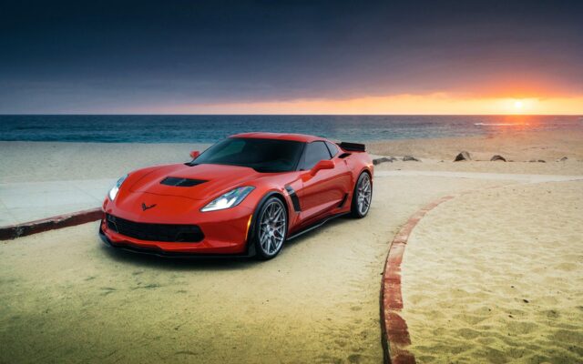 Red Chevrolet Corvette Parked By The Beach During Sunset Perfect Wallpaper Background