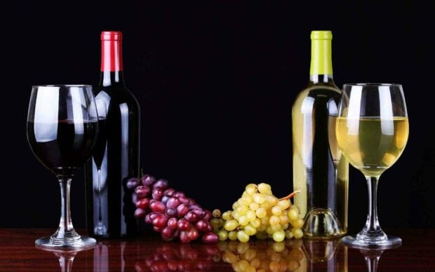 Two glasses of red and white wine next to bunches of red and green grapes on a wooden surface, HD Desktop Wallpaper