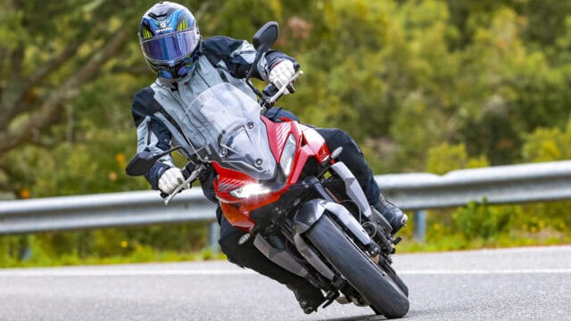 Rider Leaning into Curve on Red Triumph Tiger Sport 660 Motorcycle Wallpaper