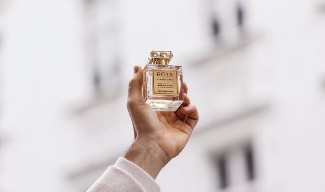 Roja Dove Amber Aoud Perfume Captured In Hand For Elegant Wallpaper