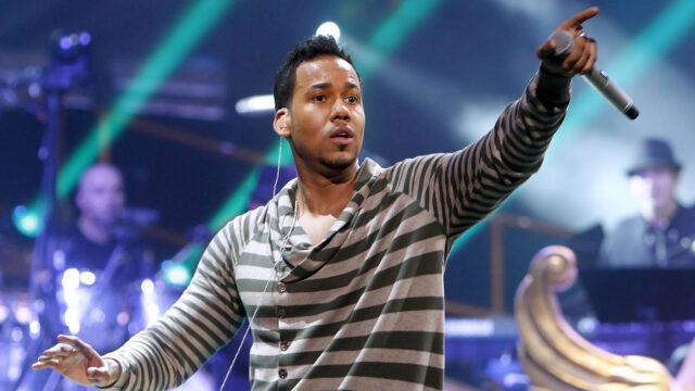 Romeo Santos Performing Live on Stage   Vibrant Concert Wallpaper