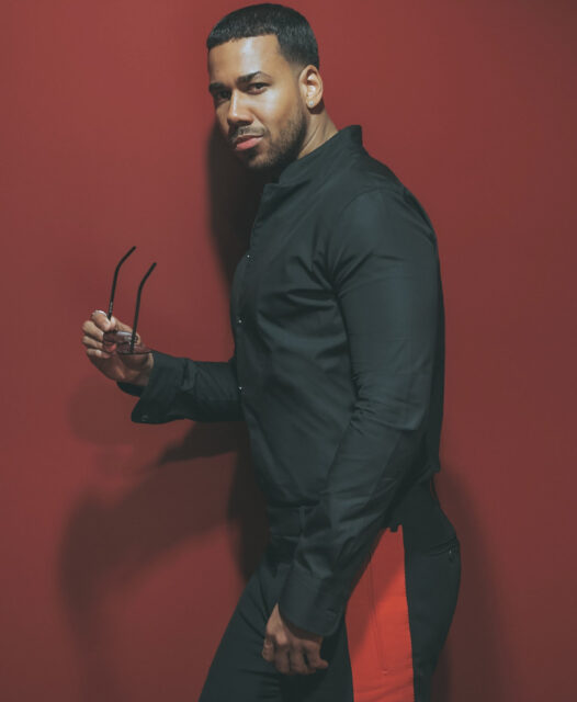 Romeo Santos Stylish Pose Red Background Wallpaper