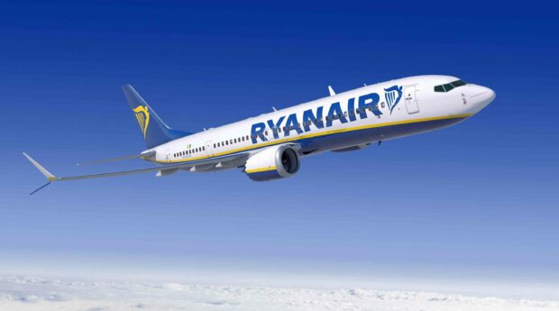 A Ryanair airplane is flying high above the clouds with a clear blue sky in the background, 2K Desktop Wallpaper