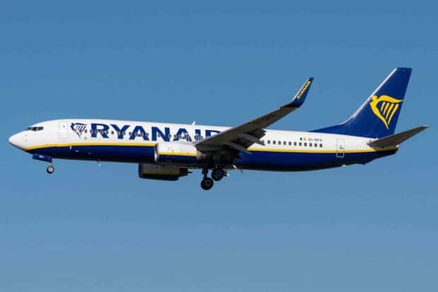 A Ryanair airplane is captured mid flight against a clear blue sky, displaying its distinct logo and colors, HD Desktop Wallpaper