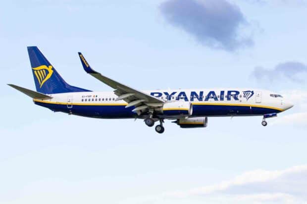 A Ryanair airplane is flying through a clear sky with its landing gear deployed, HD Desktop Wallpaper
