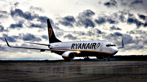 A Ryanair airplane is preparing for takeoff on the runway under a cloudy evening sky, HD Desktop Wallpaper