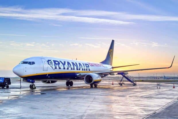 A Ryanair airplane is parked on the wet runway during sunrise with clear skies, HD Desktop Wallpaper
