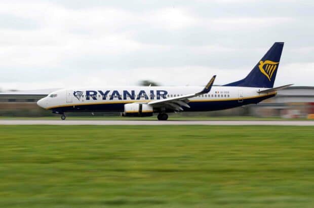 A Ryanair airplane is seen taxiing swiftly on the airport runway during a cloudy day, 2K Desktop Wallpaper