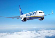 A Ryanair aircraft flying in a clear blue sky above the white clouds, 2K Desktop Wallpaper