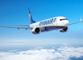 A Ryanair aircraft flying in a clear blue sky above the white clouds, 2K Desktop Wallpaper