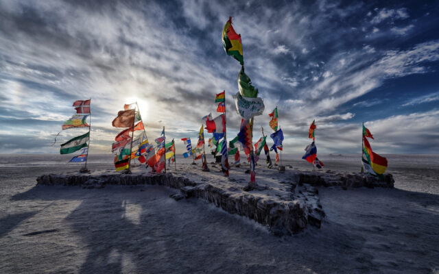 Salar De Uyuni Bolivia Colorful Flags on Salt Flat Under Dramatic Sky Wallpaper