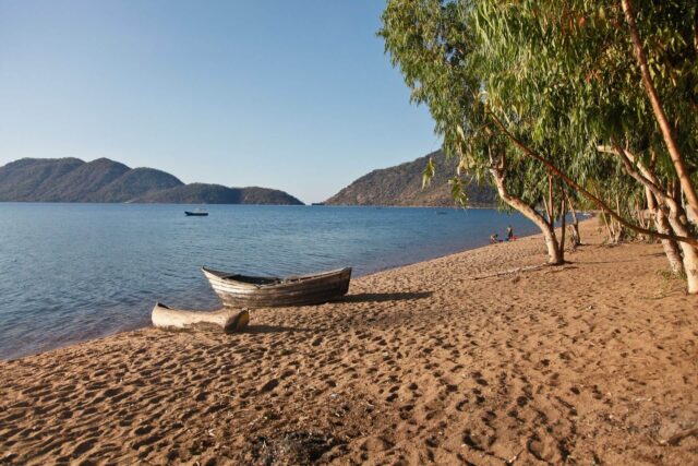 Serene Beach At Lake Malawi With Scenic Boat View