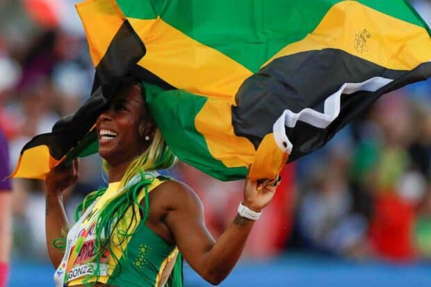 Shelly Ann Fraser Pryce holds the Jamaican flag and smiles after her race, HD Desktop Wallpaper