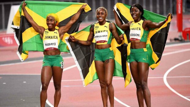 Shelly Ann Fraser Pryce and her teammates hold Jamaican flags after a race, 2K Desktop Wallpaper