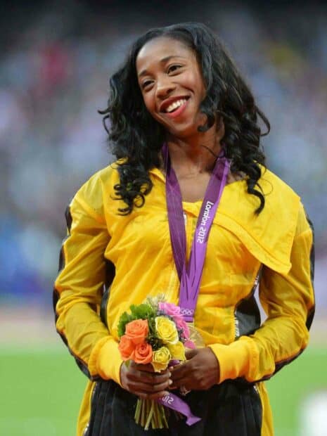 Shelly Ann Fraser Pryce is celebrating her victory at the London 2012 Olympics with a gold medal and flowers