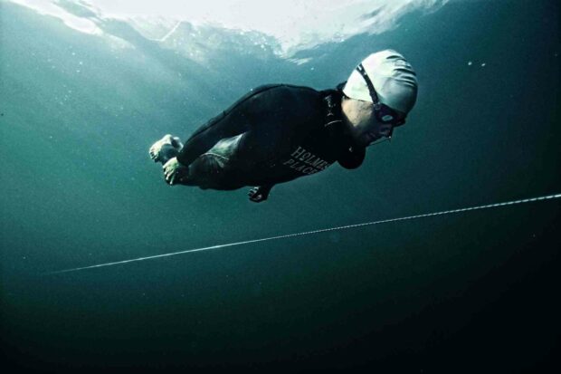 A freediver swims calmly underwater near a guide line in deep blue sea, HD Desktop Wallpaper