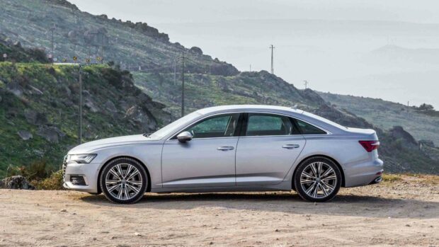A silver Audi A6 parked on a dirt road with rocky hills in the background, HD Desktop Wallpaper