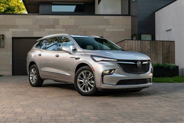 A silver Buick Enclave is parked on a stone driveway in front of a modern house with a stone and wood facade, HD Desktop Wallpaper