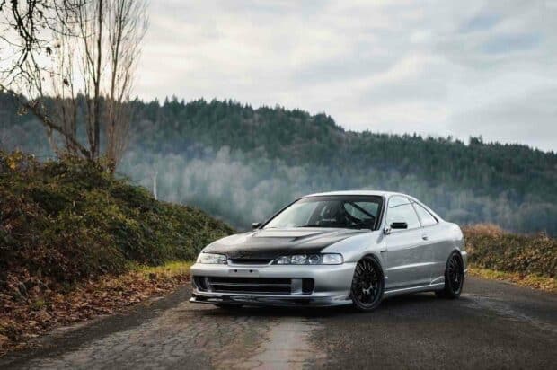A silver Honda Integra with a black hood is parked on a country road surrounded by autumn foliage and forest hills, HD Desktop Wallpaper