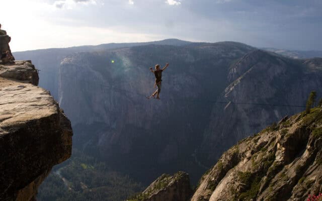 Slacklining Wallpaper Highliner Balancing Over Deep Canyon in Scenic Mountain Landscape