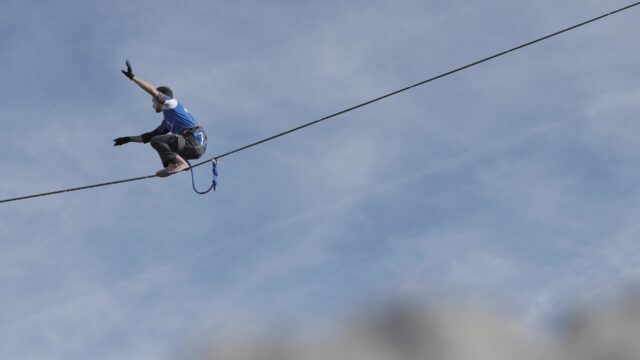 Slacklining Wallpaper with Man Balancing on Highline Against Blue Sky Background
