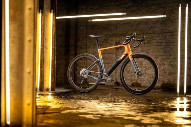 A 3T bike stands inside an industrial setting with glowing yellow and white lights, HD Desktop Wallpaper