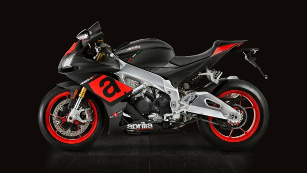 A sleek Aprilia motorcycle with red rims is showcased against a dark background in Aprilia Wallpapers, 4K Desktop Wallpaper