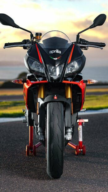 The Aprilia motorcycle displays a front view with detailed headlights and red accents, 2K Mobile Wallpaper