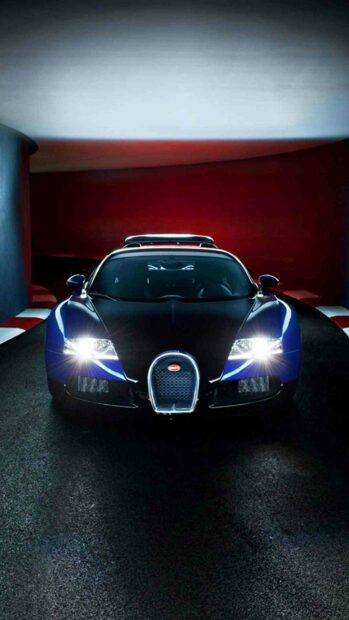 A blue and black Bugatti Veyron is displayed with headlights on in a dimly lit environment, HD Phone Wallpaper
