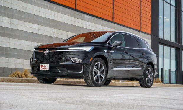 A black Buick Enclave is parked on the street with a modern building background, HD Desktop Wallpaper