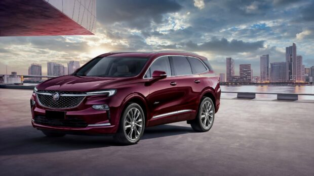 A sleek maroon Buick Enclave parked on a rooftop with a city skyline under a cloudy sky in the background, 4K Desktop Wallpaper