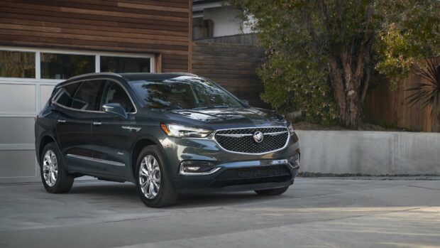 A sleek Buick Enclave is parked on a driveway next to a modern house with wooden siding, 4K Desktop Wallpaper