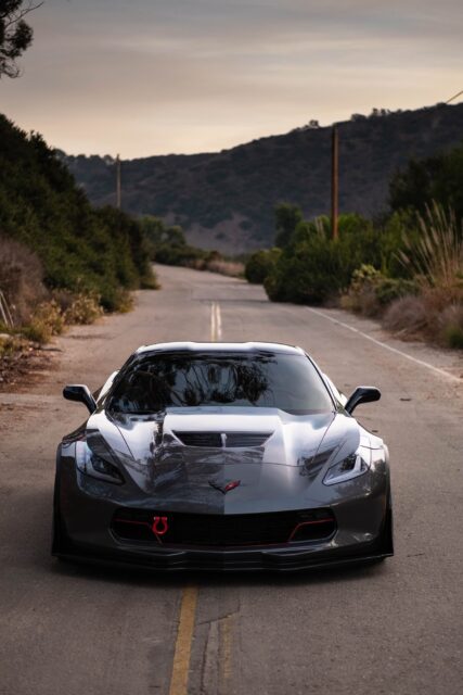 Sleek Chevrolet Corvette Sports Car On Scenic Road Ideal Wallpapers