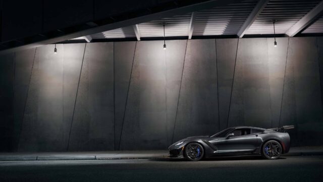 Sleek Chevrolet Corvette Parked Under Urban Streetlights Dark Wall Background Wallpaper