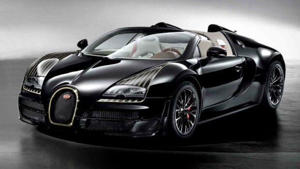 A black Bugatti Veyron with gold detailing is shown in a studio setting highlighting its luxury design, HD Desktop Wallpaper