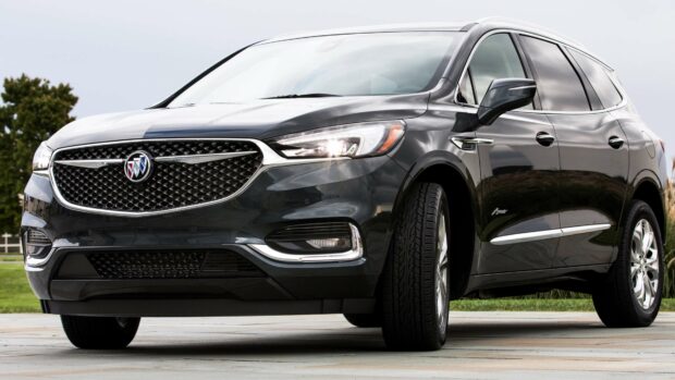 A sleek black Buick Enclave SUV is parked outdoors on a cloudy day, showcasing its front grille and design features, 4K Desktop Wallpaper