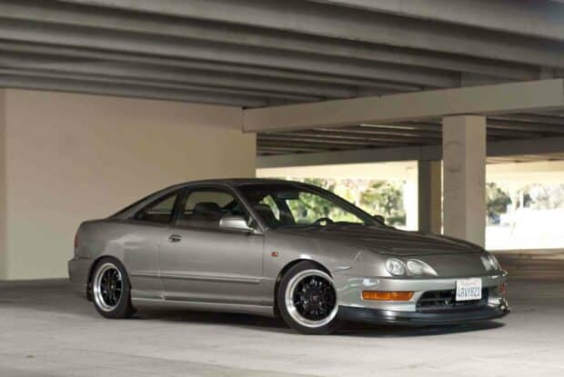 A sleek silver Honda Integra coupe is parked in an urban underpass with detailed black rims, HD Desktop Wallpaper