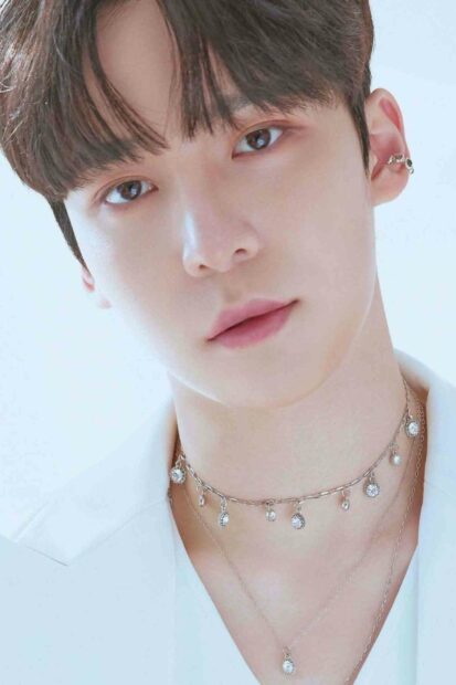 A close up of Jeong Yun Ho wearing earrings and layered necklaces in a soft light setting, HD Mobile Wallpaper