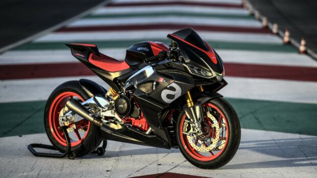 A sporty Aprilia motorcycle stands on a racetrack with red and black details, 2K Desktop Wallpaper
