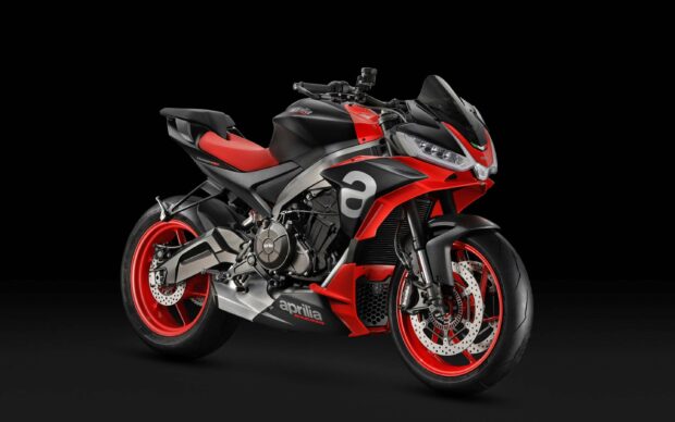 A sporty Aprilia motorcycle with red and black accents is showcased against a dark background, 2K Desktop Wallpaper